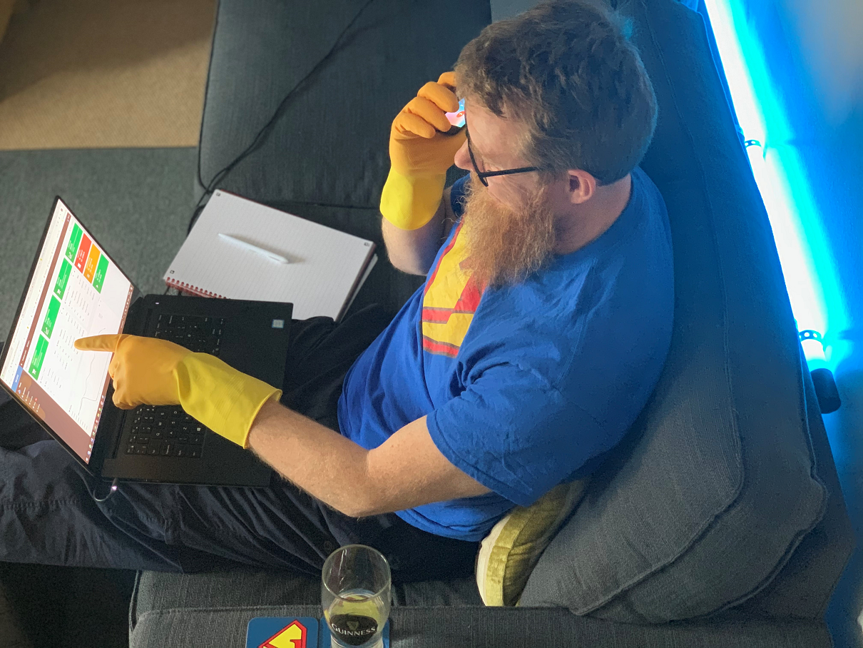 Kieran Kelly, Kerridge systems K8 specialist consultant, with super7 T-shirt, slippers, working on his laptop wearing marigold gloves….